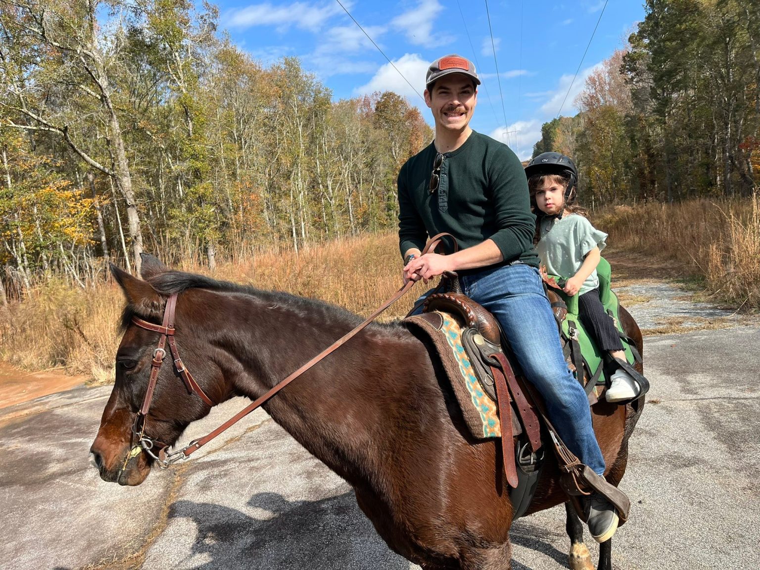 An instructor guiding a young rider on horseback